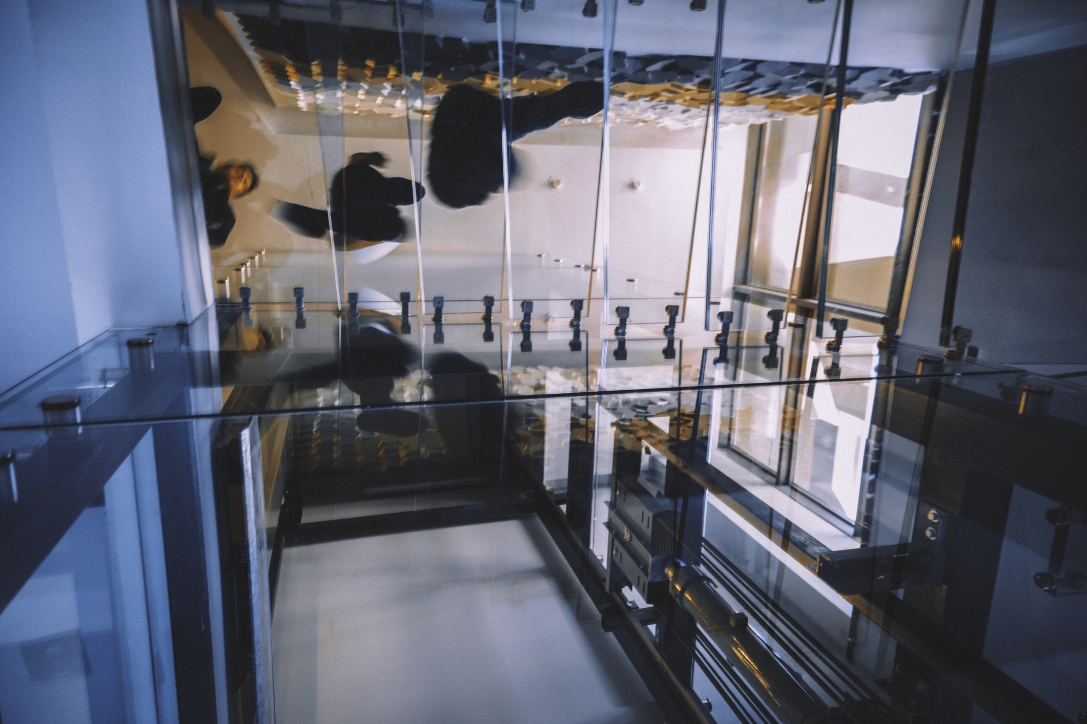 Motion blur of people walking on transparent glass spiral staircase in futuristic building on a contemporary office