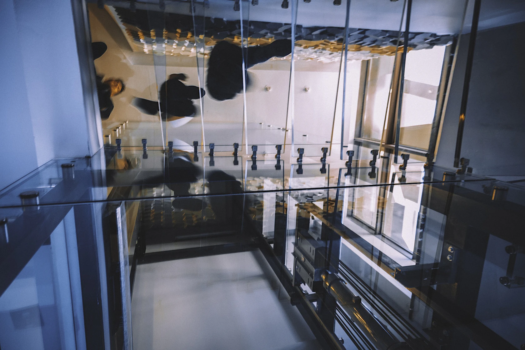 Motion blur of people walking on transparent glass spiral staircase in futuristic building on a contemporary office