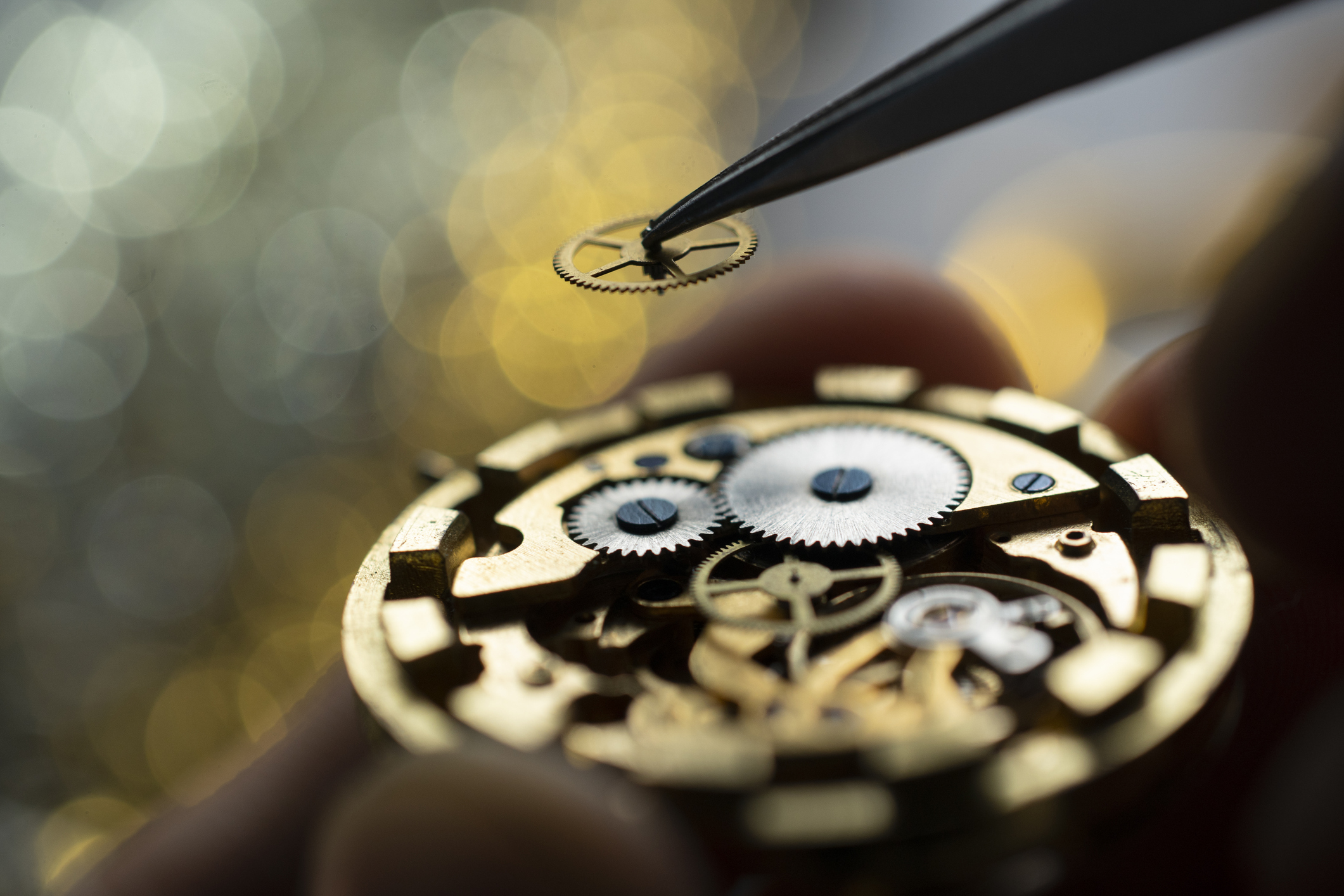 Pocket watch being repaired by senior watch maker, close-up. Black and white.