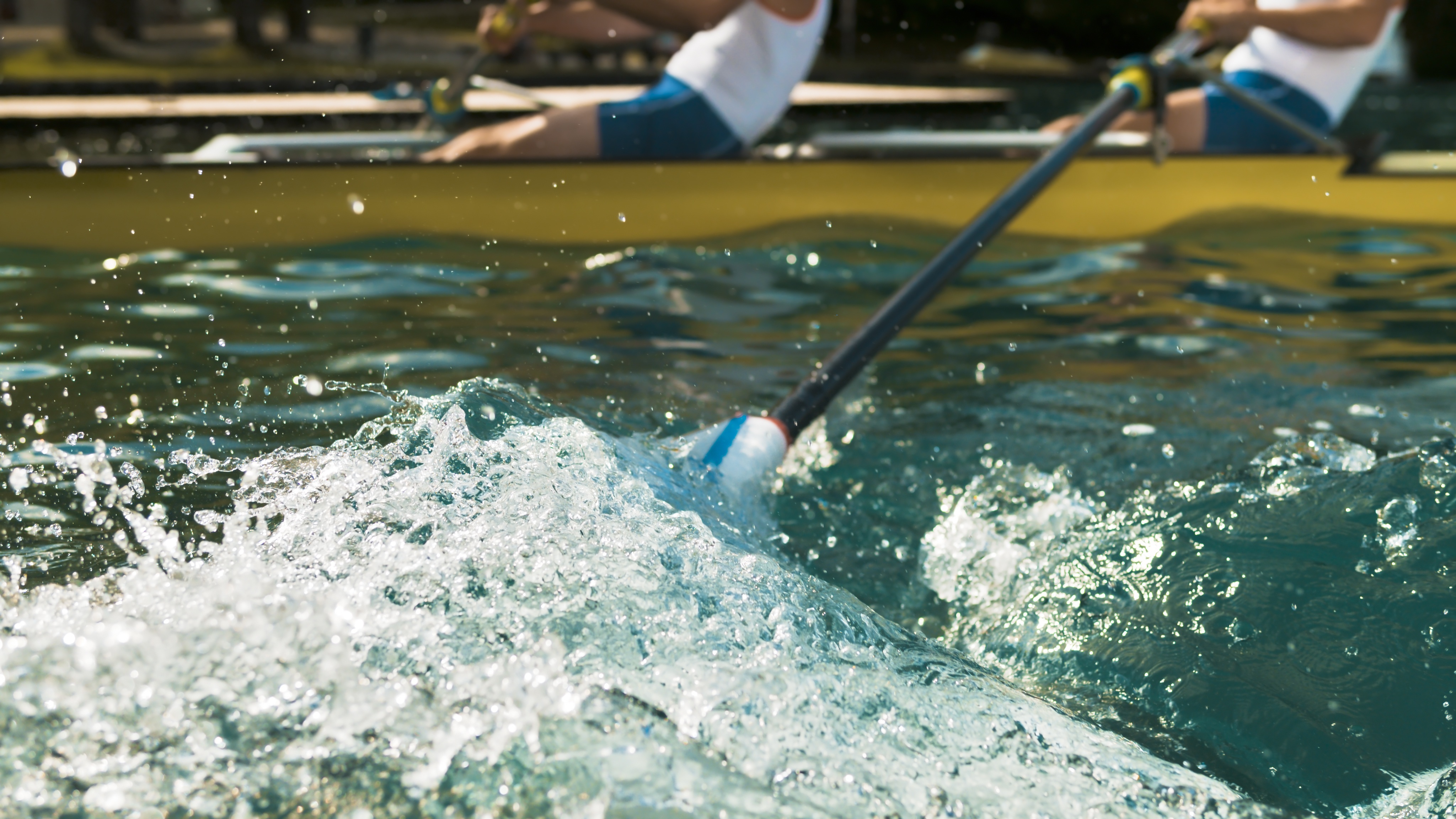 Oar splashing water in lake.